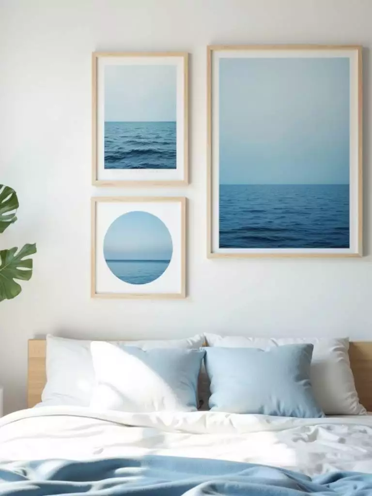 Bedroom wall with calming blue nature-inspired art prints depicting ocean scenes in soft tones and light wood frames, creating a serene atmosphere.