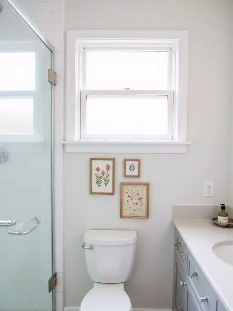 Bathroom with DIY gallery wall featuring pressed flowers, paint chips, and a nautical chart.