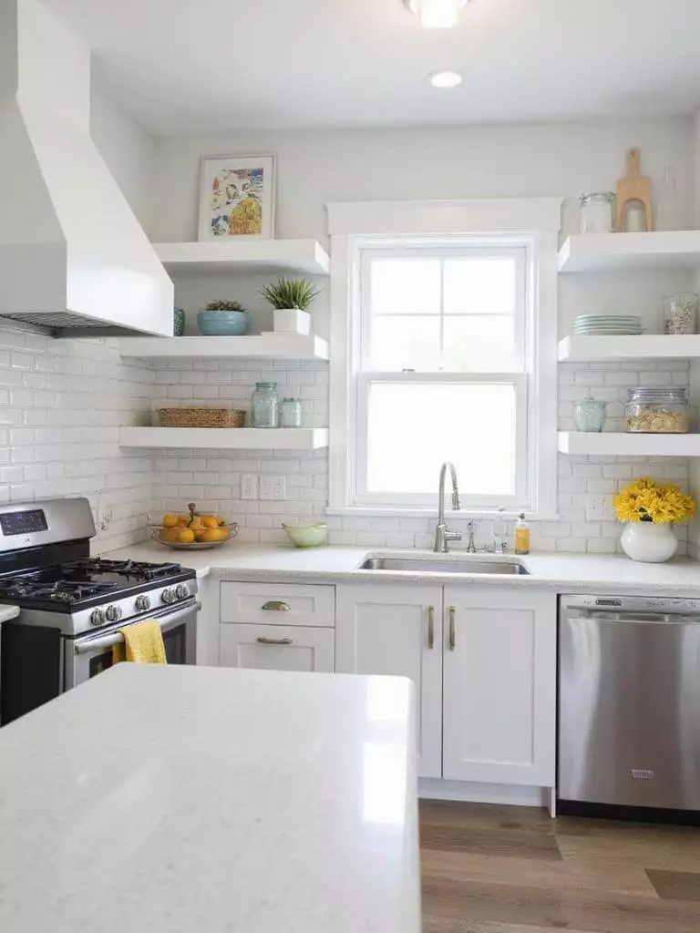 Durable and easy-to-clean materials in a small kitchen remodel: quartz countertops, ceramic tile backsplash, stainless steel appliances, and LVT flooring.