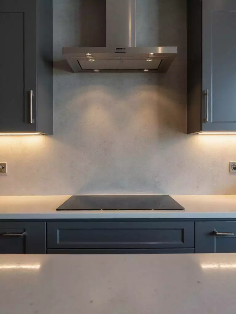 Modern kitchen with polished concrete backsplash and stainless steel appliances