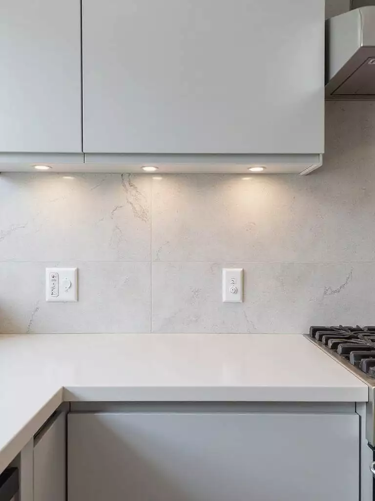 Modern kitchen with large format light gray porcelain backsplash