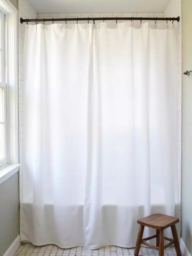 White linen shower curtain in a bright farmhouse bathroom