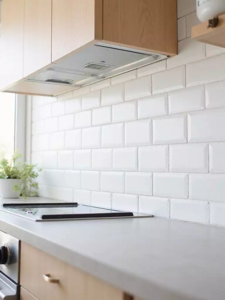Modern kitchen backsplash featuring oversized matte white subway tiles in a vertical stacked pattern.