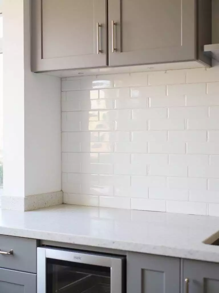 Contemporary kitchen backsplash with vertical stacked white subway tiles
