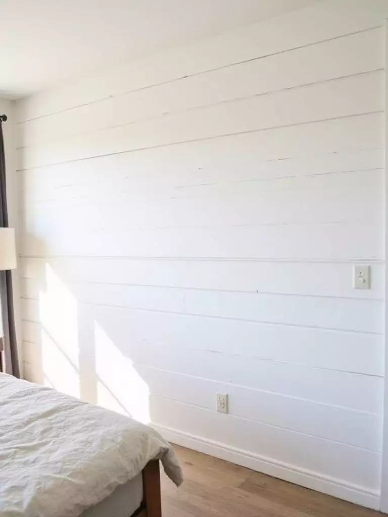 Farmhouse bedroom with white shiplap wall