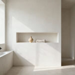 Minimalist bathroom interior featuring open shelving with significant negative space, a simple ceramic item, and natural light, illustrating Zen bathroom organization principles.