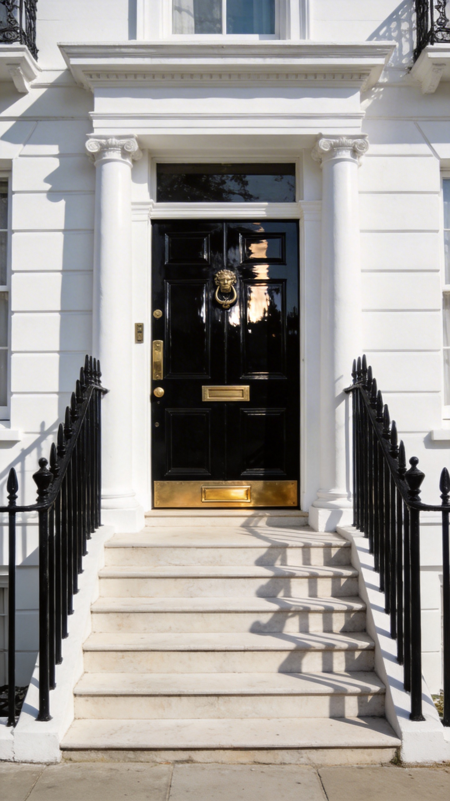 A sophisticated Georgian porch featuring a high-gloss London Black front door and brilliant white masonry and columns.