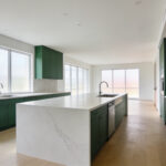 A bright and spacious modern kitchen renovation showcasing a multi-zone layout with a large island and contemporary finishes.